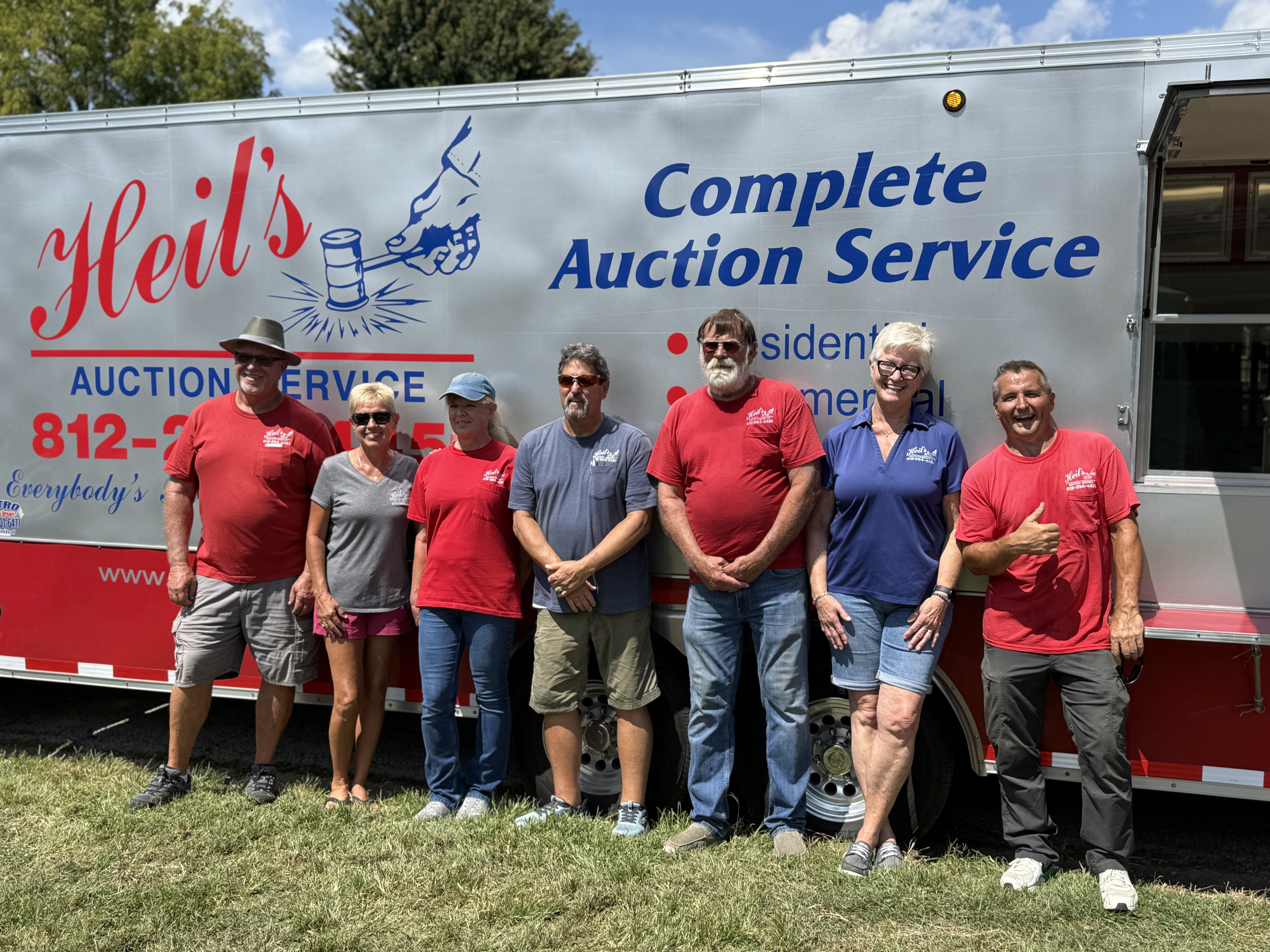 Heil's Auction Service team in front of the auction trailer